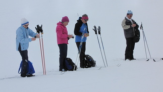 Iiris, Ulla, Ritva sekä Kiilopäällä hiihtelemässä ollut ranskalaismies hörppäävät lämmintä juotavaa.