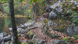 Polku mahtuu juuri ja juuri kulkemaan rannan ja kallion välissä.