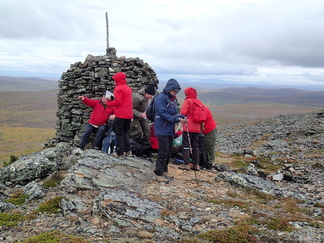 Huipulla tuulee, eli eväät keräännyttiin syömään kivikasan suojaan kunhan viestit kotiin oli saatu lähetettyä.