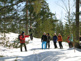 Kalevi pitää kädellään kiinni vaijerista. Ollaan Hyvinkään Erämatkat Oy:n 100 metriä pitkän rissaradan alapäässä. Yritys järjestää Usmissa seikkailuhenkisiä aktiviteetteja, mm laskeutumista vaijeria pitkin kallioiden välisen kanjonin yli.