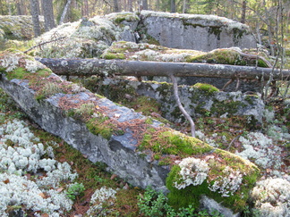 Maastossa näkyy merkkejä kivenlouhinnasta lähestyttäessä Iso-Karhulampea.