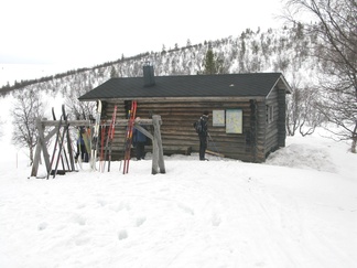 Raurulammen rantatörmällä seisoo pieni päivätupa.